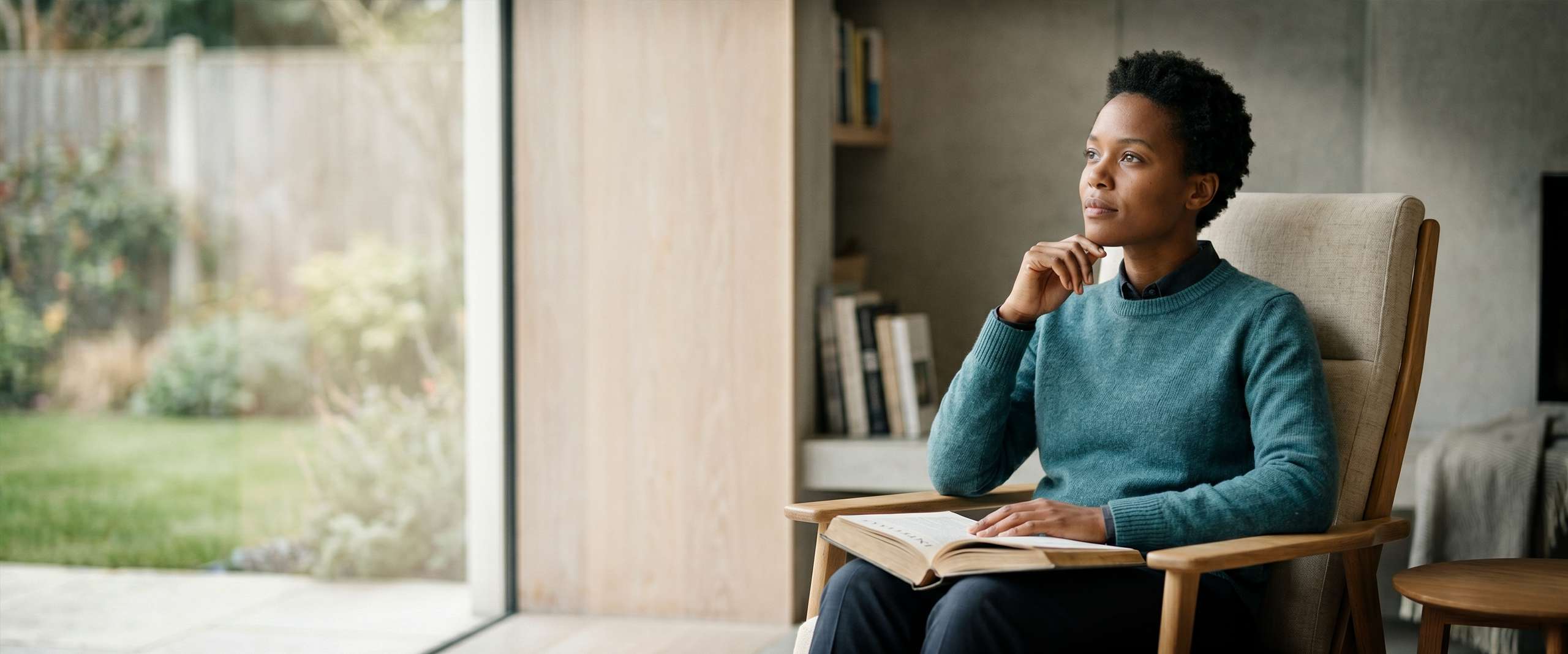 A focused woman, thoughtfully introspecting in a calm, distraction-free reading nook, illustrating cognitive ease with Accruva, an ADHD & neurodivergent reading app